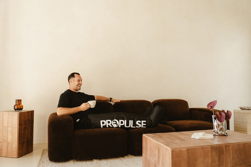 Man relaxing at home in compression boots after training
