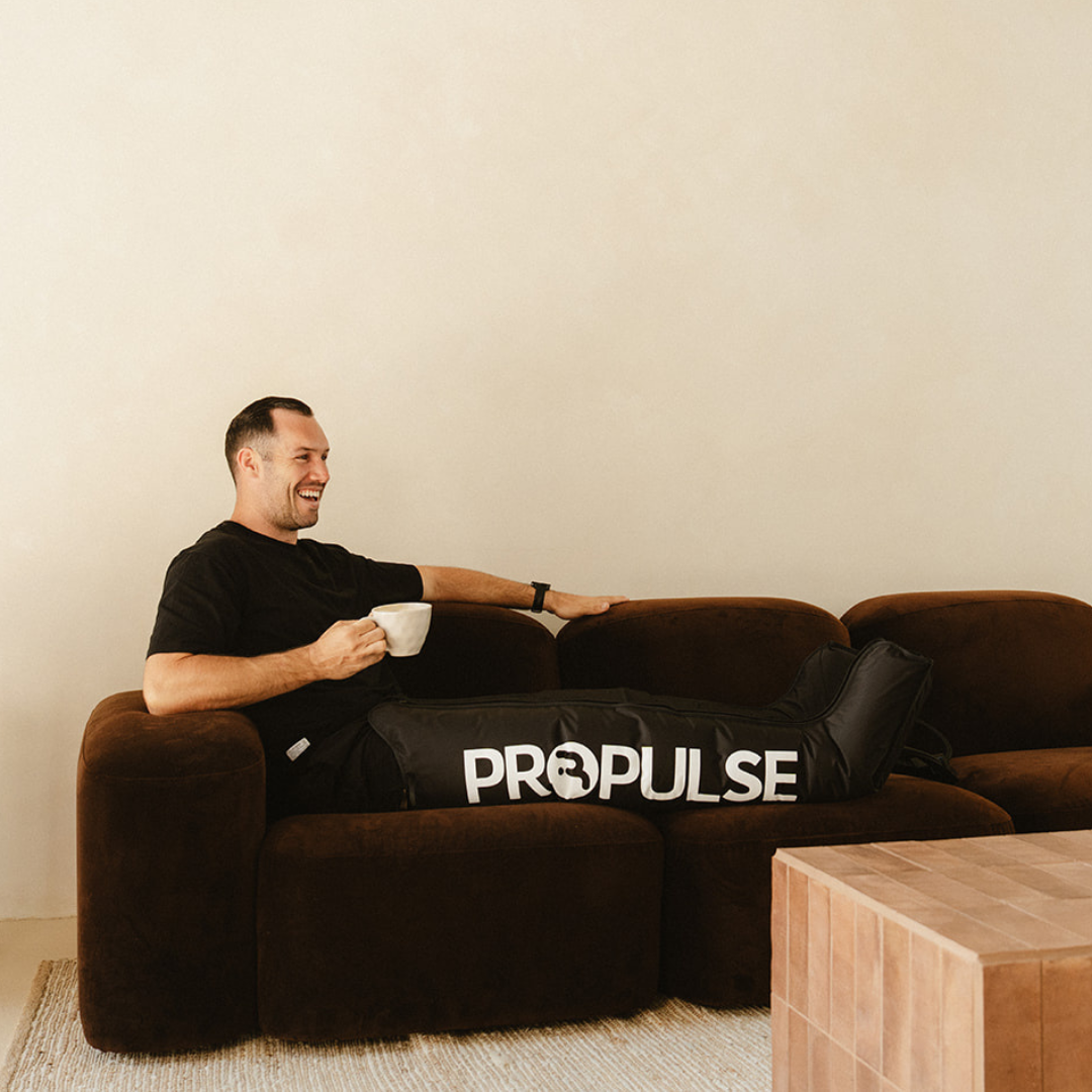 Man relaxing on a couch wearing PROPulse compression boots